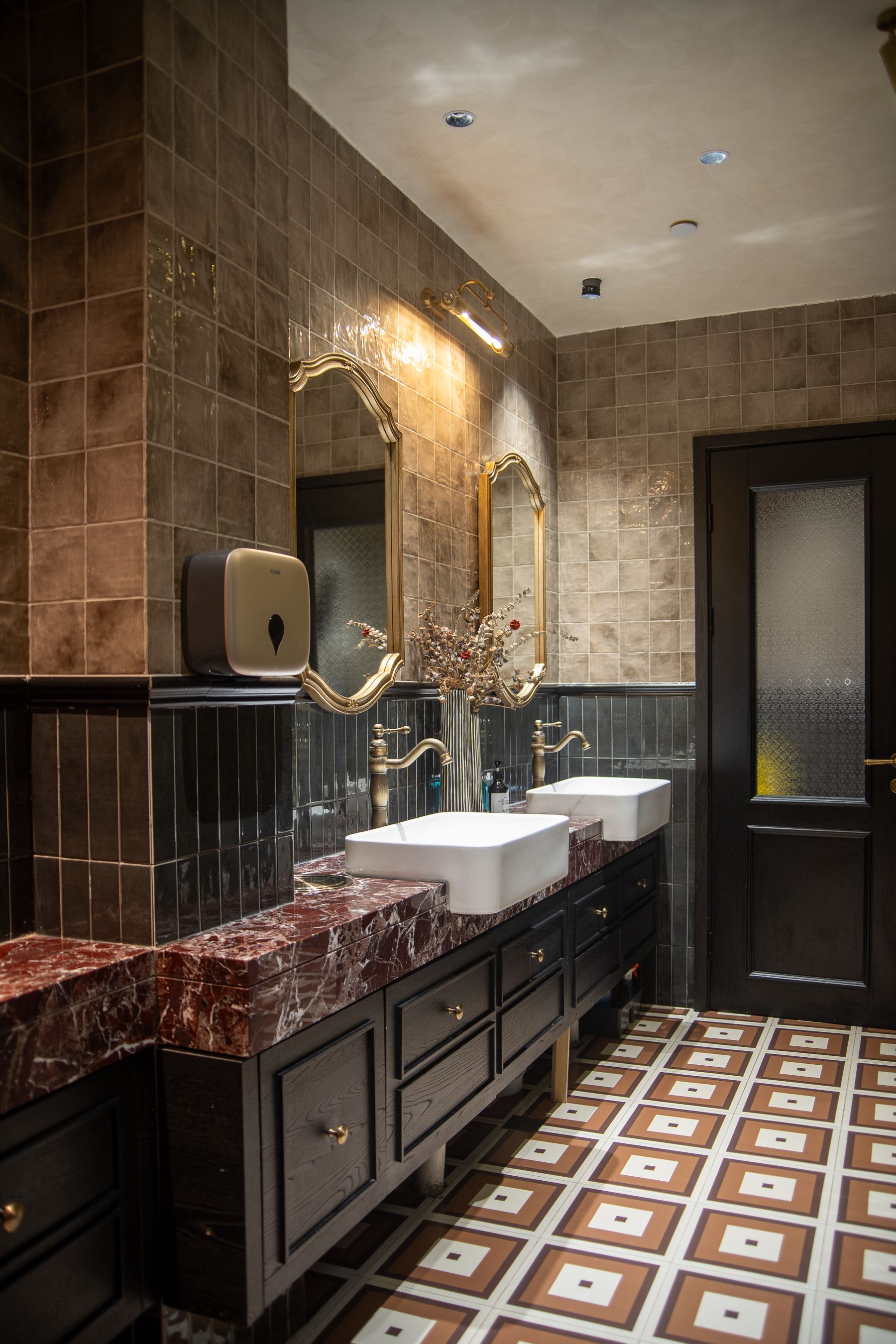 Elegant double vanity with repeated vintage-style mirrors, marble countertop and brass accents