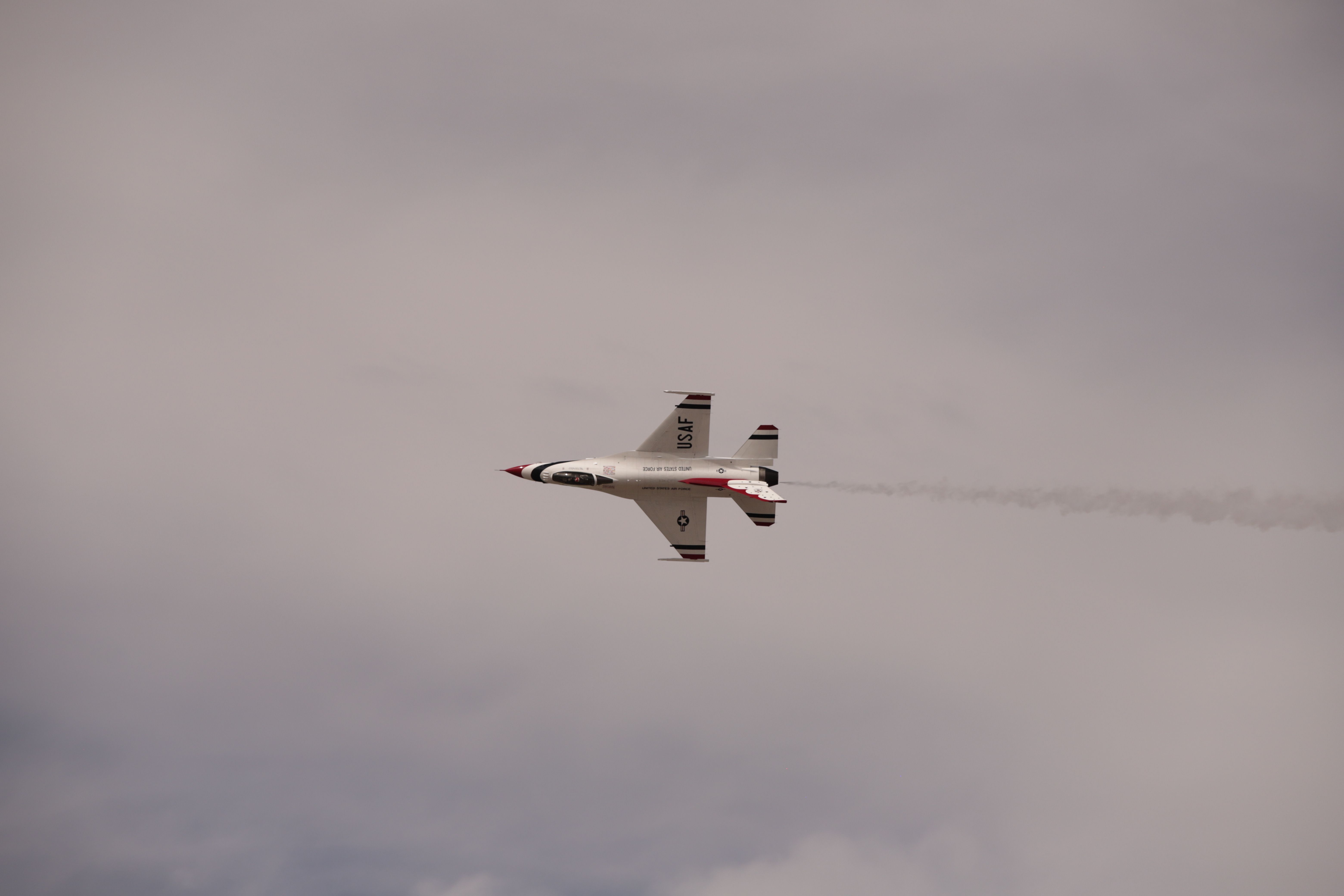 A fighter jet flying under an overcast sky