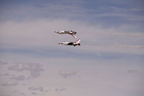 Free Two military jets performing an impressive aerial maneuver against a blue sky. Stock Photo