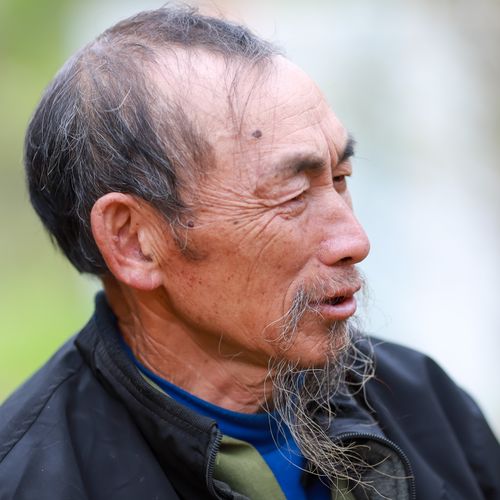 Free Close-up portrait of an elderly Hmong man outdoors, showcasing traditional features and attire in Lào Cai, Vietnam. Stock Photo