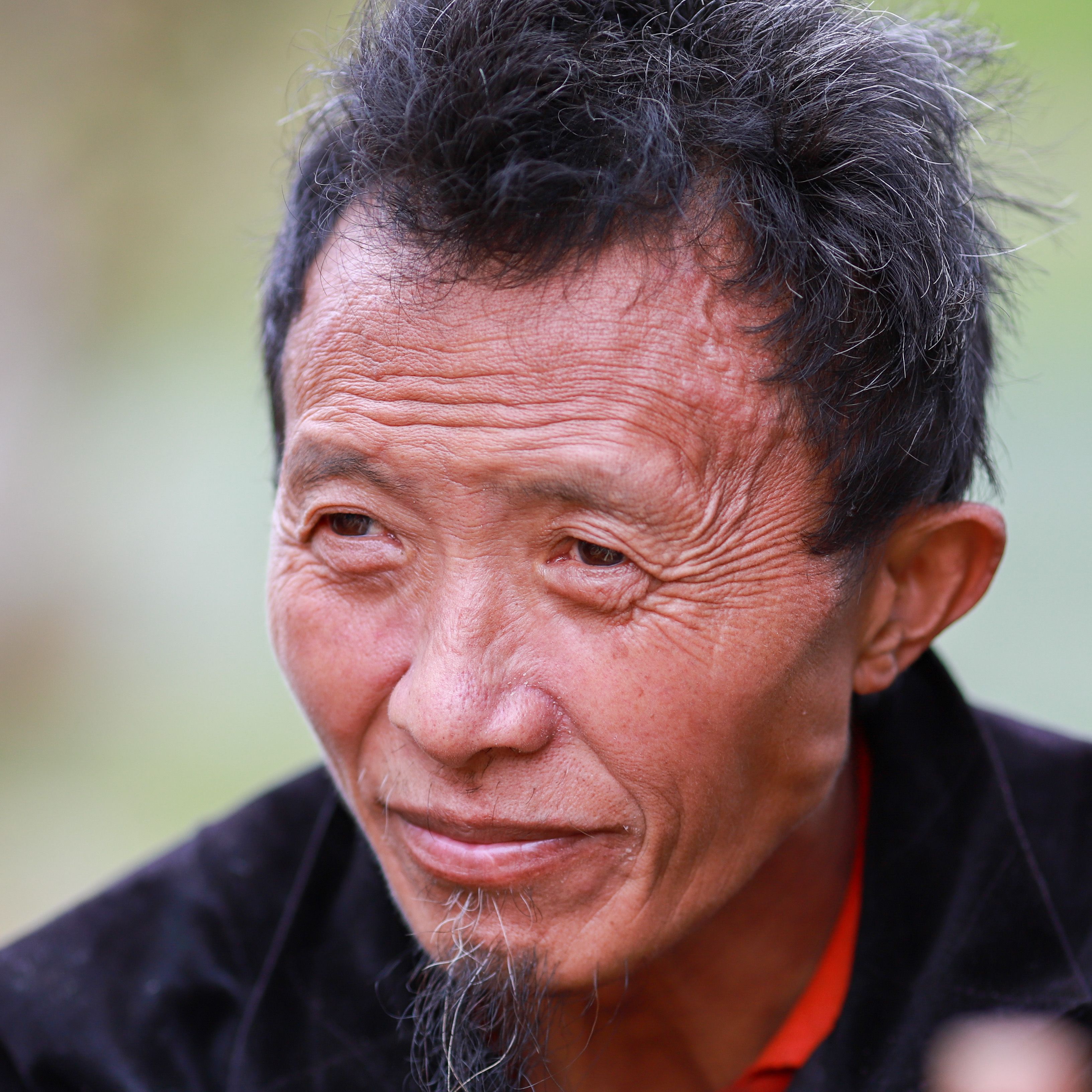 Close-up portrait of a Hmong elder man with traditional clothing in Lào Cai, Vietnam.