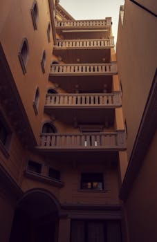 Elegant multi-story building facade in an urban courtyard setting with architectural details.