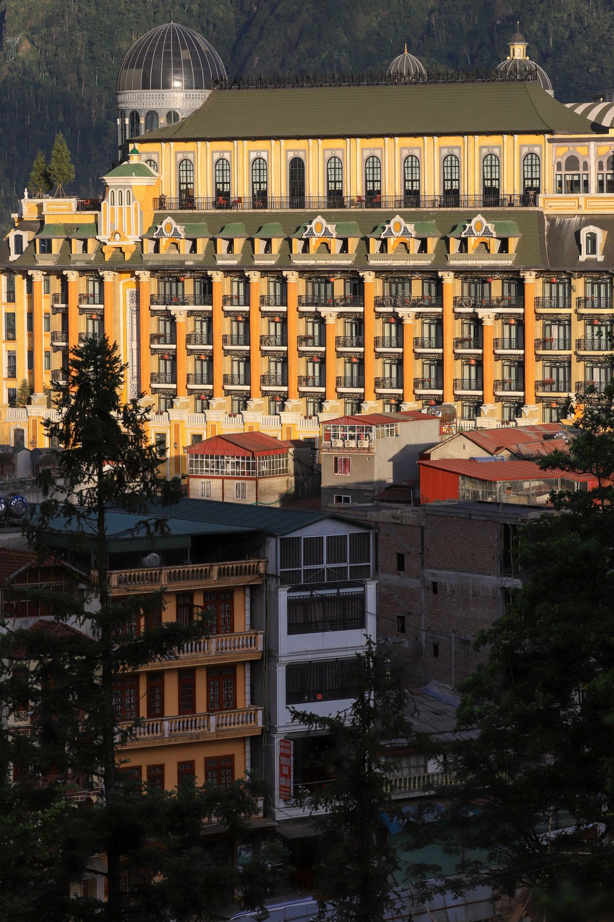 Large yellow hotel building among buildings in Sapa town