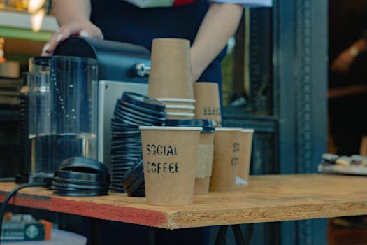Close-up of barista preparing coffee with takeaway cups at an Argentine café.
