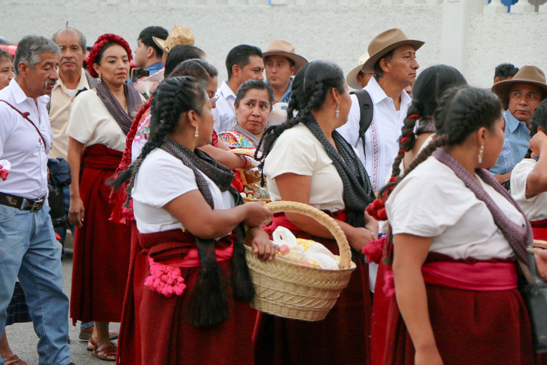 Group of people in traditional attire participating in a cultural festival parade outdoors.