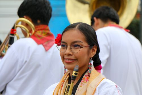 Free Smiling young woman in traditional dress playing music at a cultural festival. Stock Photo
