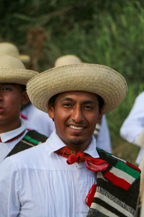 Free Smiling man in traditional attire at outdoor cultural festival. Bright and cheerful. Stock Photo