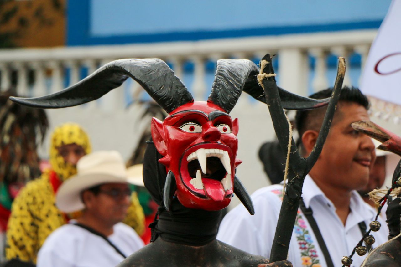 vibrant street festival featuring participants in traditional masks an