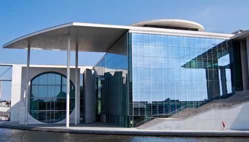 Free Contemporary building with glass façade in Berlin against a bright blue sky, showcasing modern architecture. Stock Photo