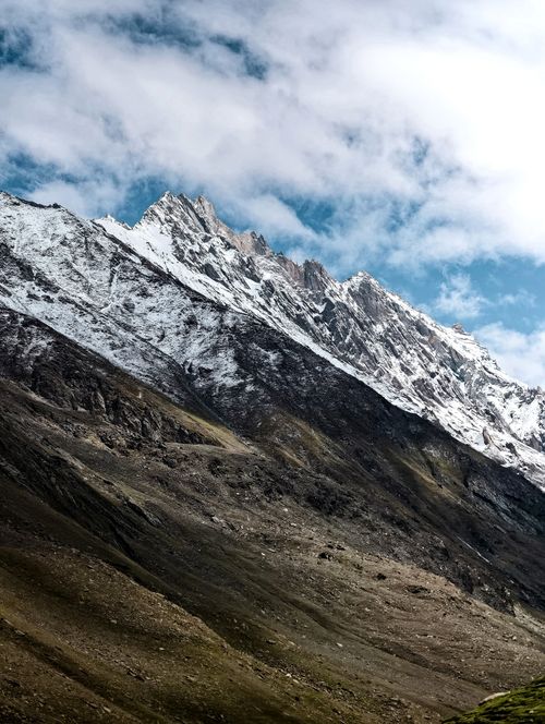 Free Stunning view of snow-covered peaks against a blue sky in Kashmir's mountain region. Stock Photo