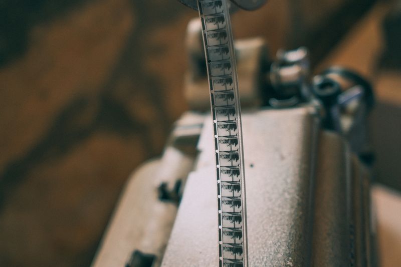 Close-up of a vintage film strip on a projector, showcasing classic cinema.