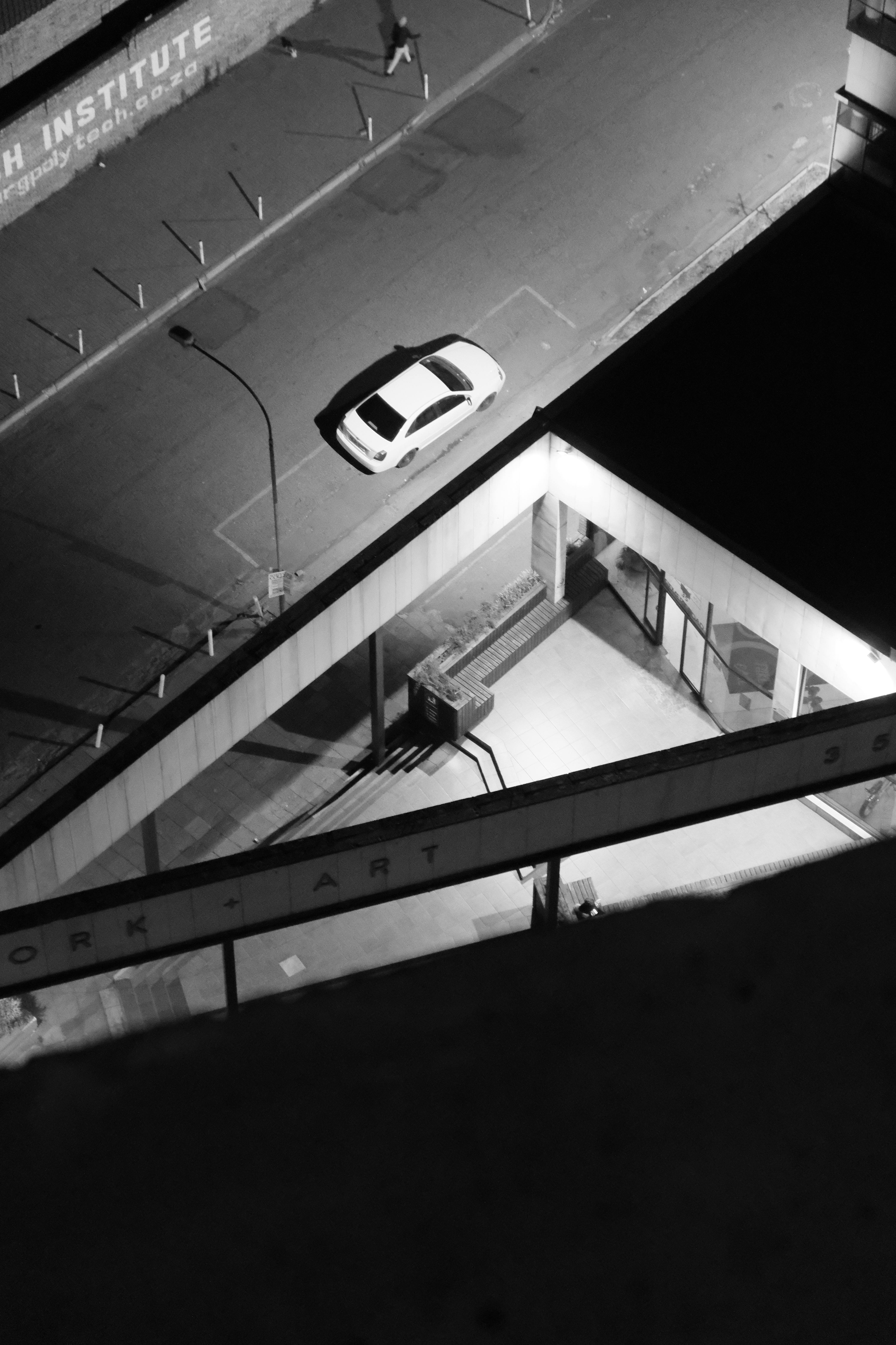 Gratuit Vedere aeriană nocturnă alb-negru a unei străzi urbane cu o mașină parcată și o clădire. Fotografie de stoc