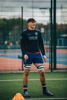 Young male rugby player in athletic gear preparing for practice on an outdoor sports field. Energetic and focused.