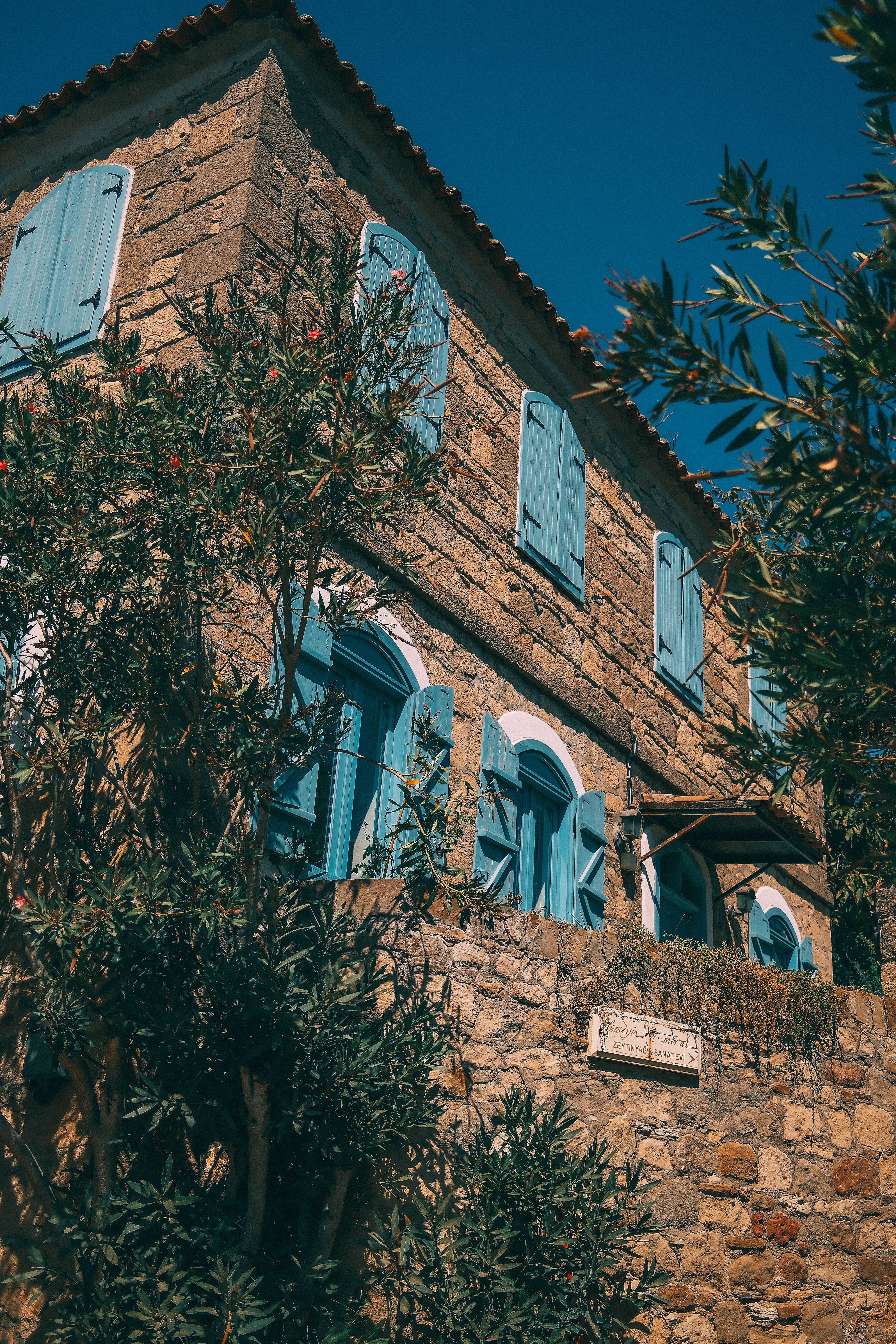 Historic Stone House with Blue Shutters in Sunlight · Free Stock Photo