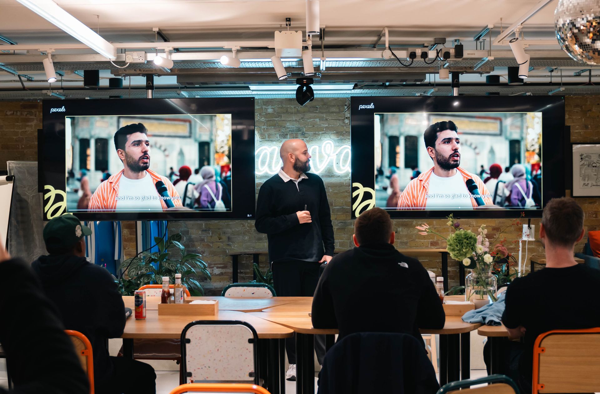A professional leads a presentation with digital displays in a modern office environment.