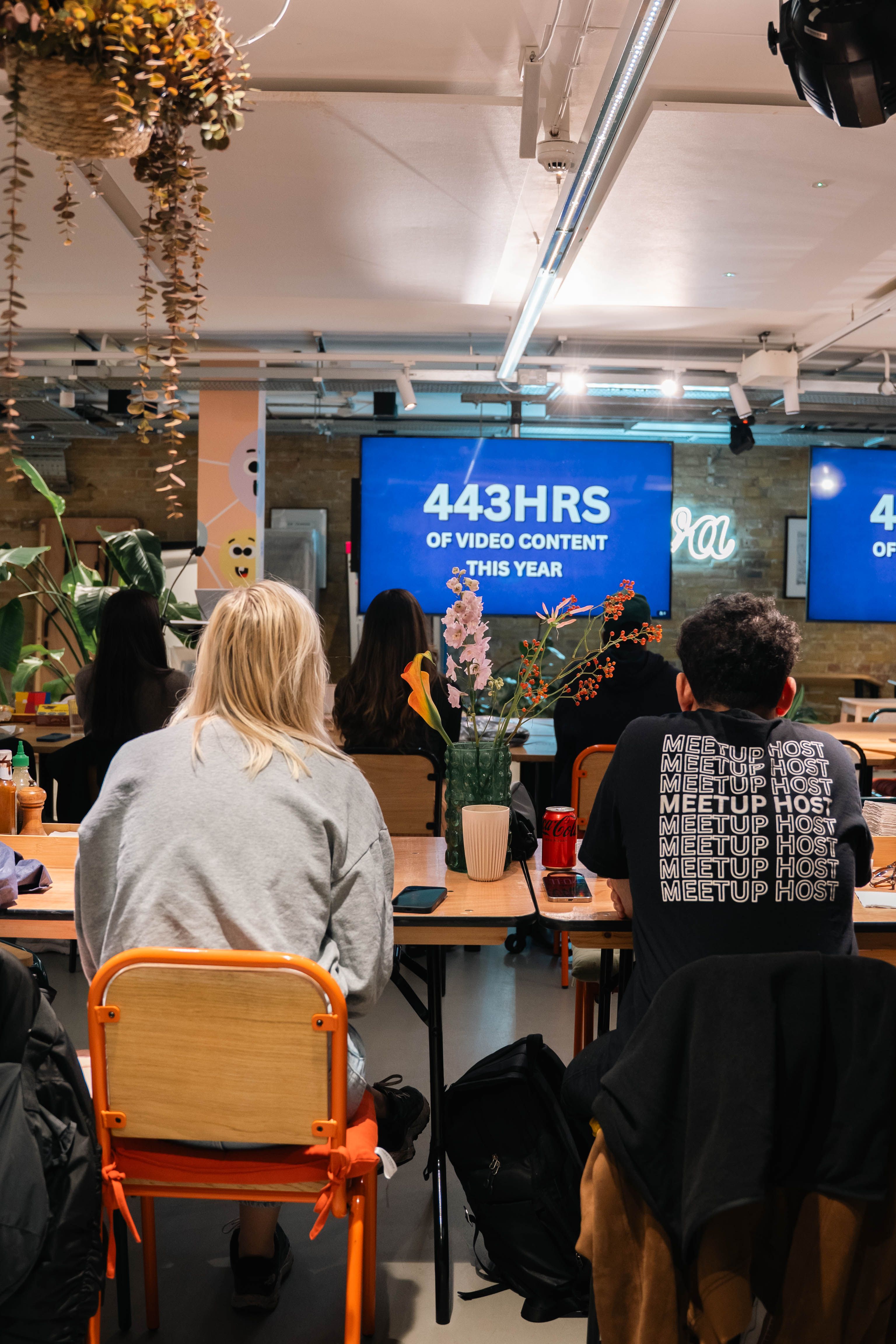 Interactive team meeting in a modern office discussing 443 hours of video content, fostering collaboration.
