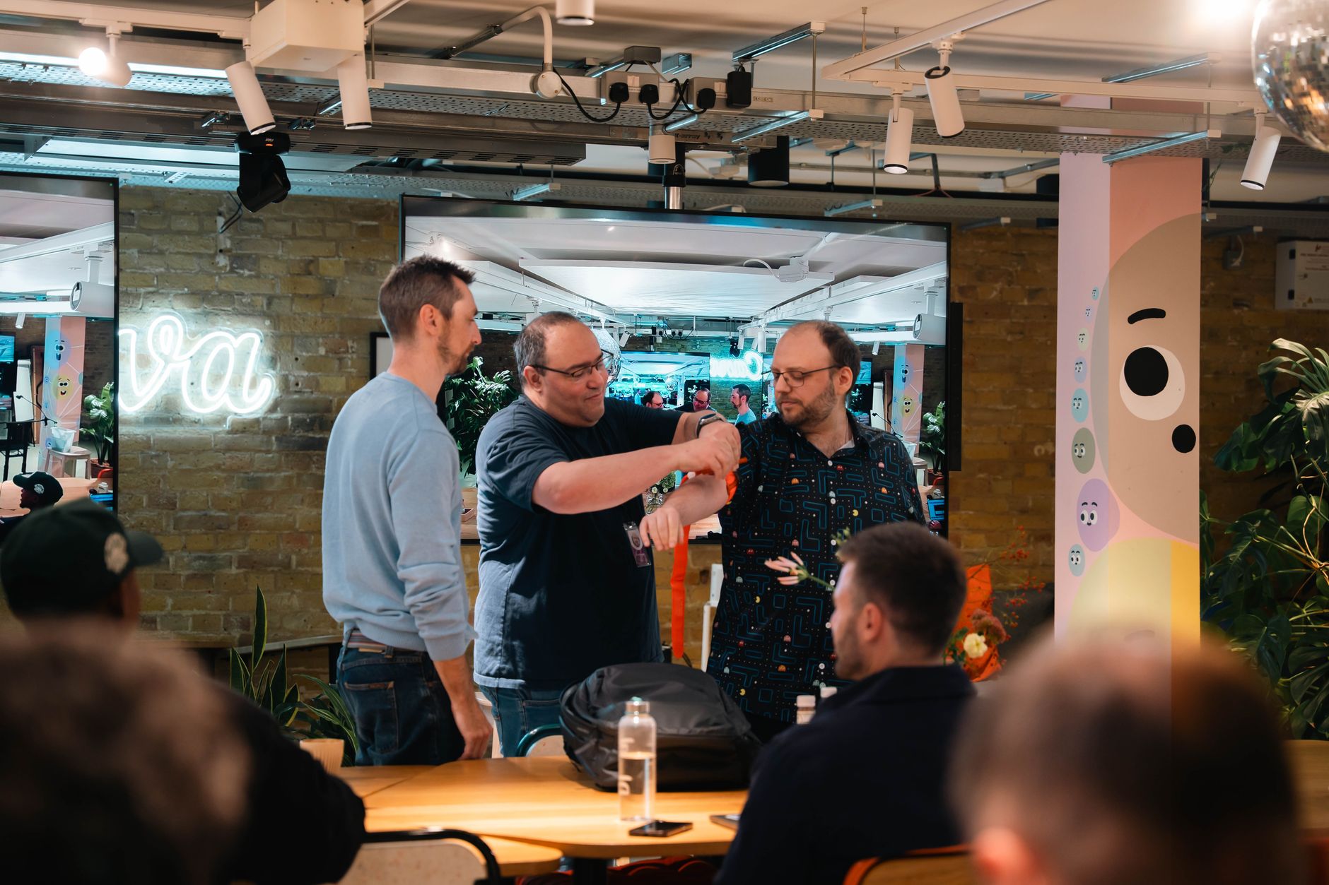 Three adults engaging in a collaborative discussion in a modern office setting.