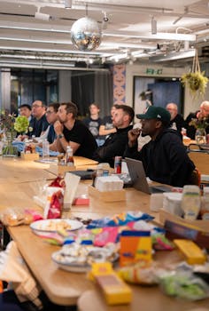 A casual office meeting in a modern setting with snacks and engaged participants.