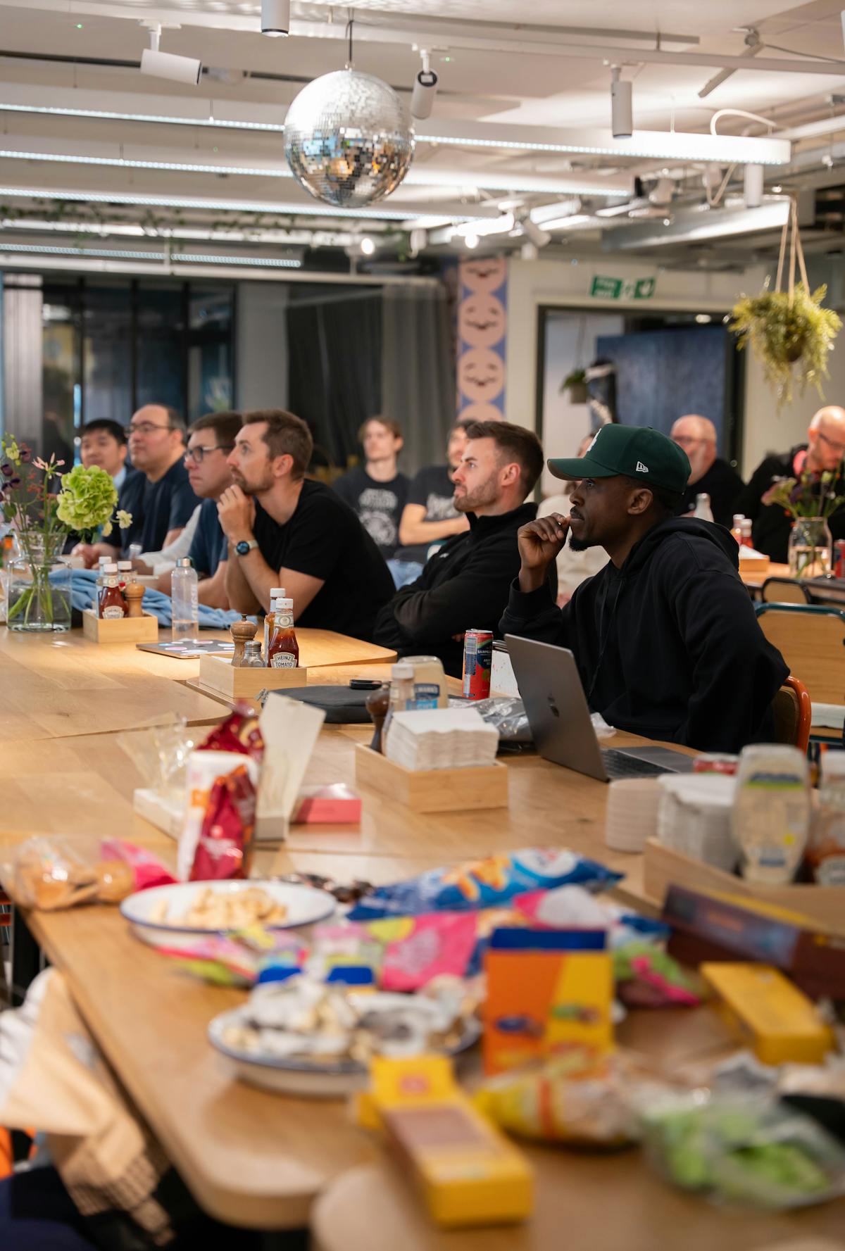 Persone sedute attorno a tavolo in ufficio con spuntini e appunti