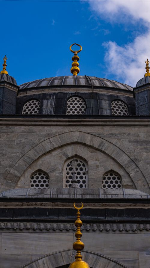 Free Close-up of Ottoman-style mosque dome with ornate details and a blue sky backdrop. Stock Photo