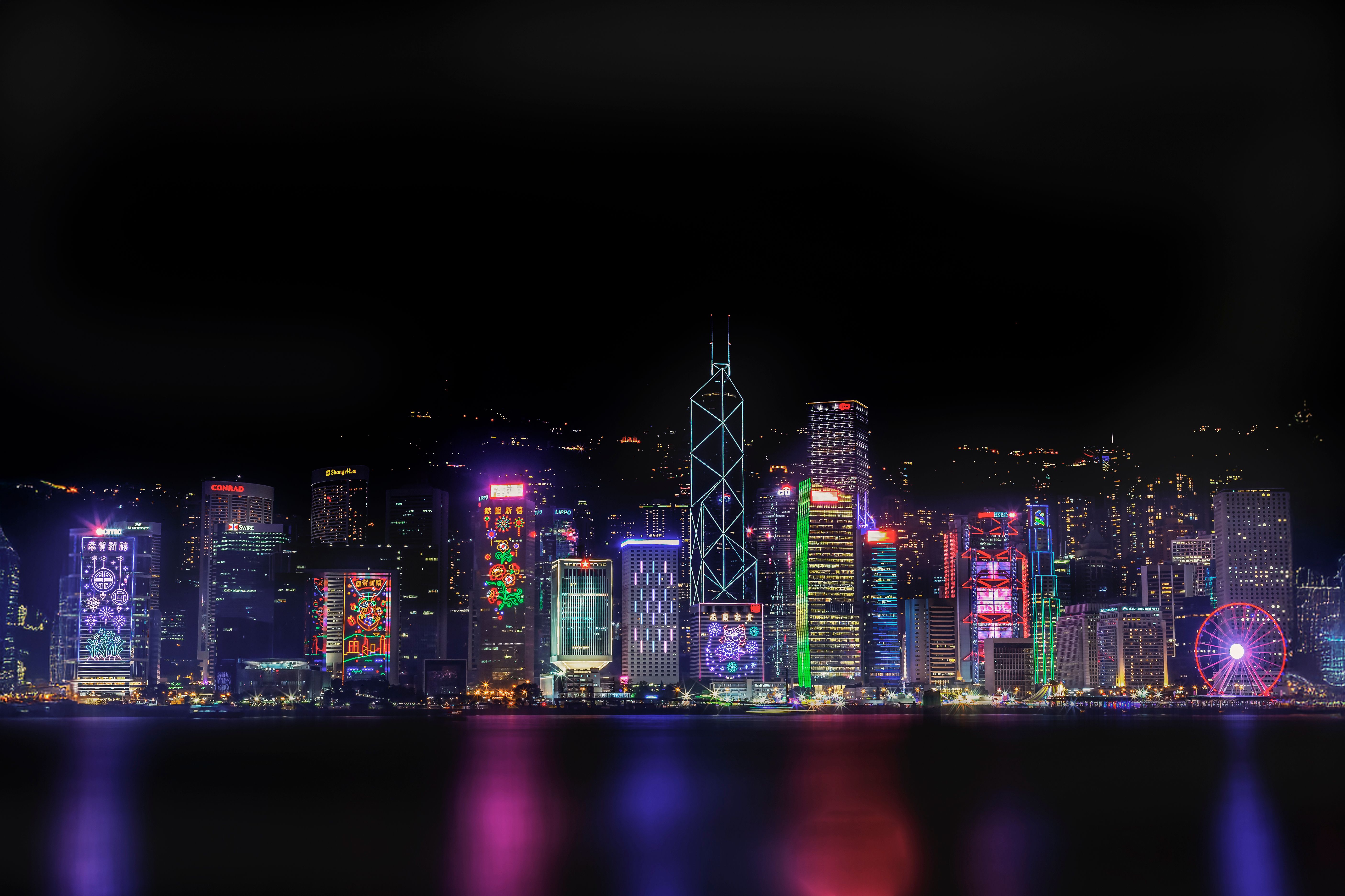 Stunning view of Hong Kong's illuminated skyline with colorful lights reflecting on the water.