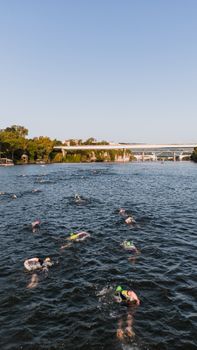 Aerial view of athletes swimming in the river during the Chattanooga Ironman triathlon event.