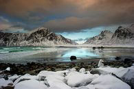 挪威弗拉克斯塔德的雪山和岩石海岸线在白天显得格外宁静