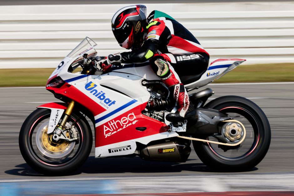Close-up of a professional motorcycle racer speeding on track. Dynamic and thrilling motorsport action.