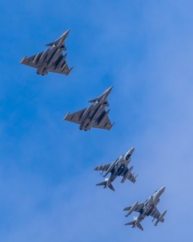 Four Dassault Rafale jets in formation against a clear blue sky, showcasing aerial military precision.