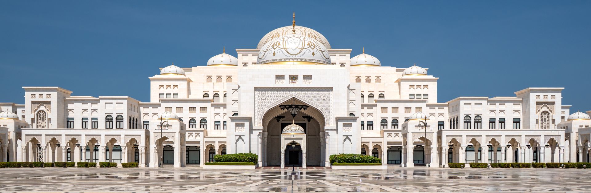 Front view of Qasr Al Watan Palace against a clear blue sky in Abu Dhabi, showcasing its grand archi