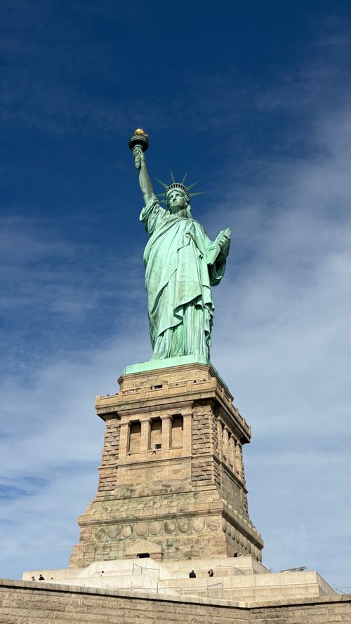 Free The iconic Statue of Liberty against a clear blue sky in New York City, symbolizing freedom and democracy. Stock Photo