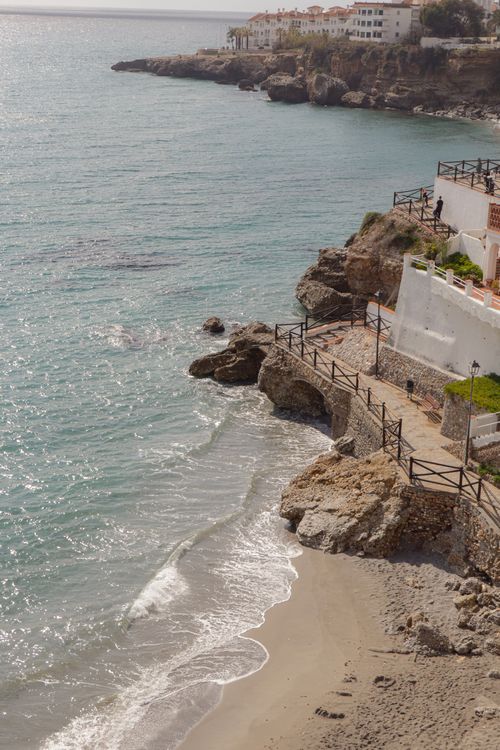 Free A picturesque coastal landscape with white buildings atop rocky cliffs overlooking the sea. Stock Photo