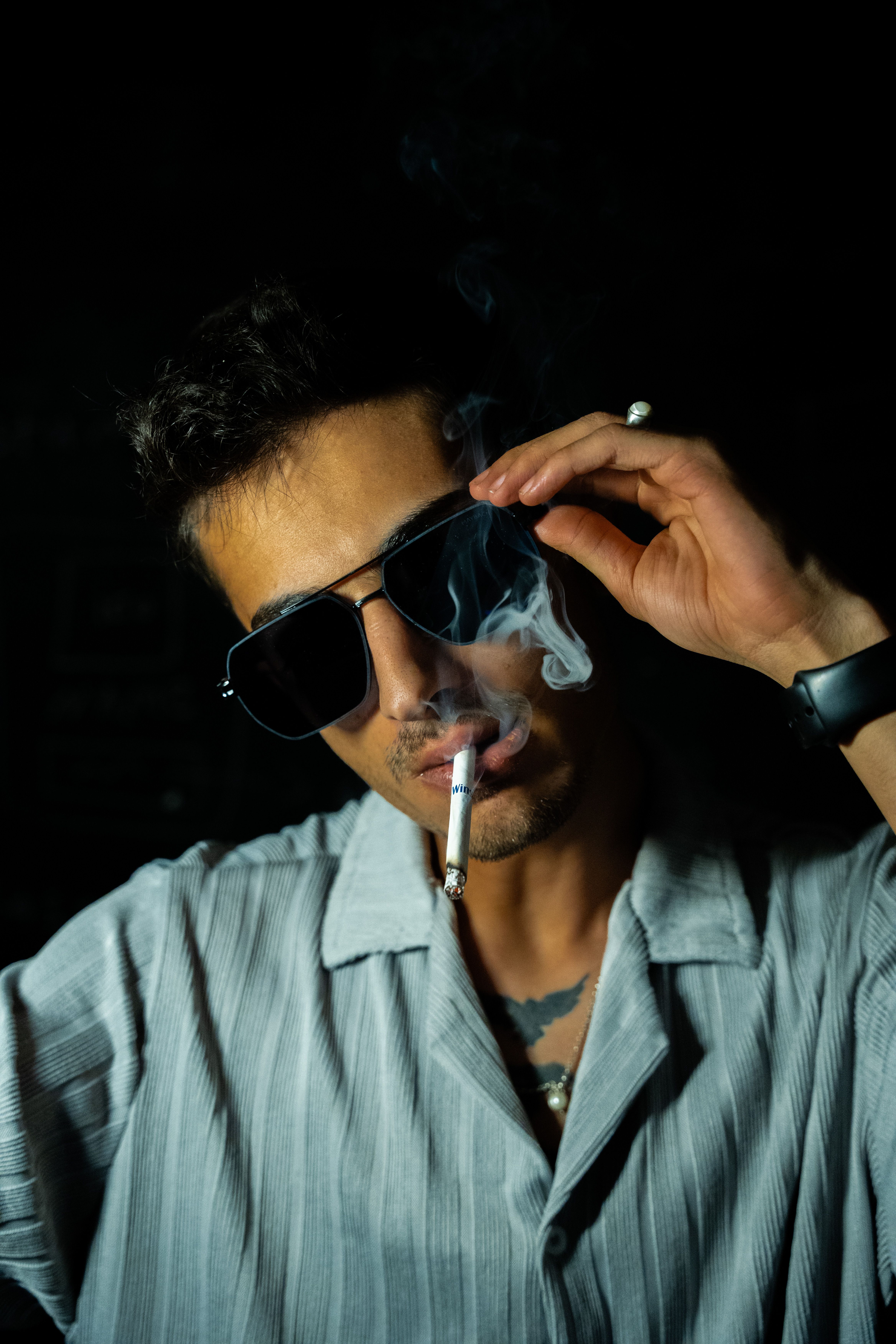 Stylish Man Smoking in Dark Dramatic Portrait · Free Stock Photo