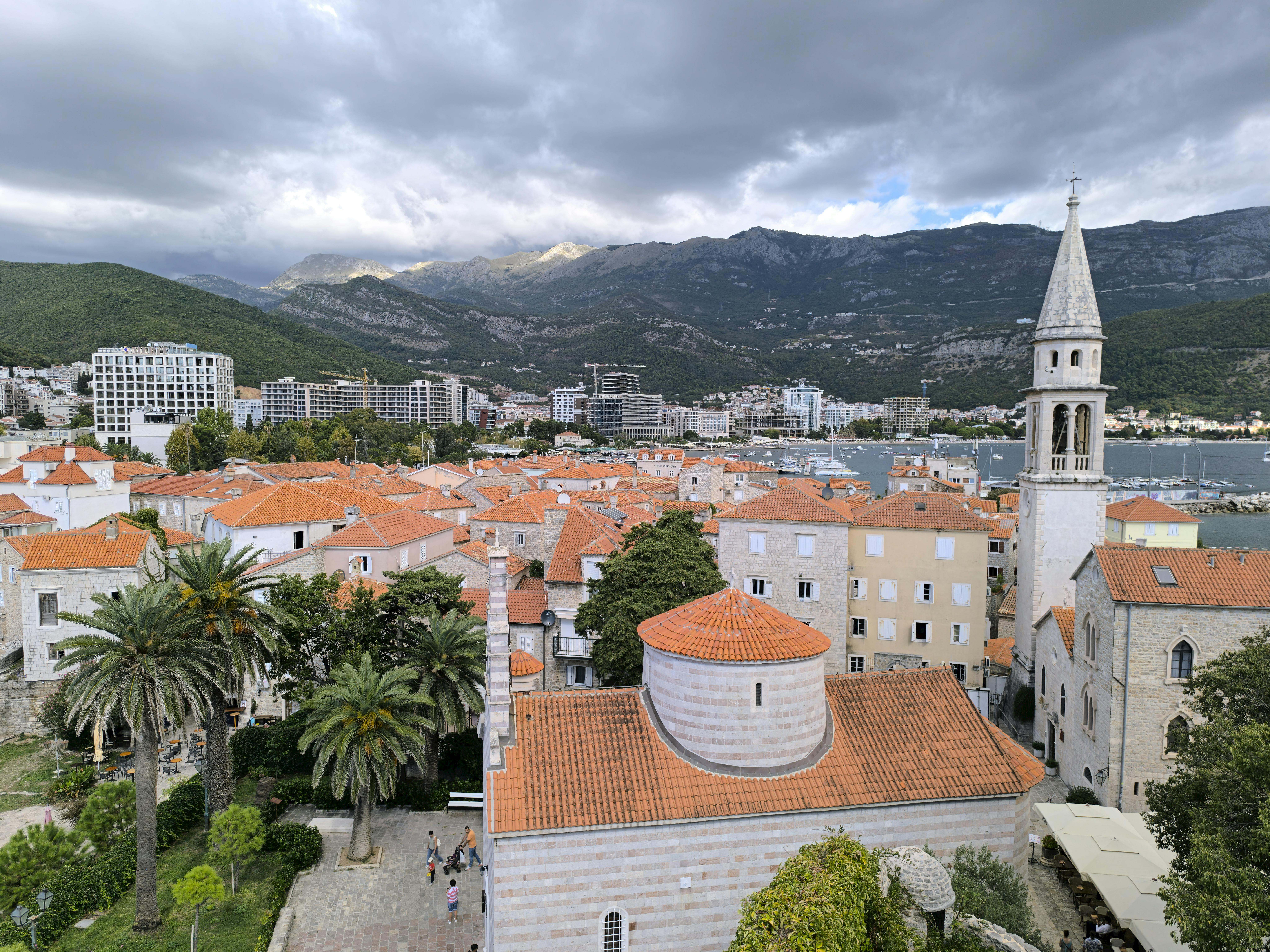Scenic view of Budva's Old Town with terracotta roofs and coastal backdrop in Montenegro.