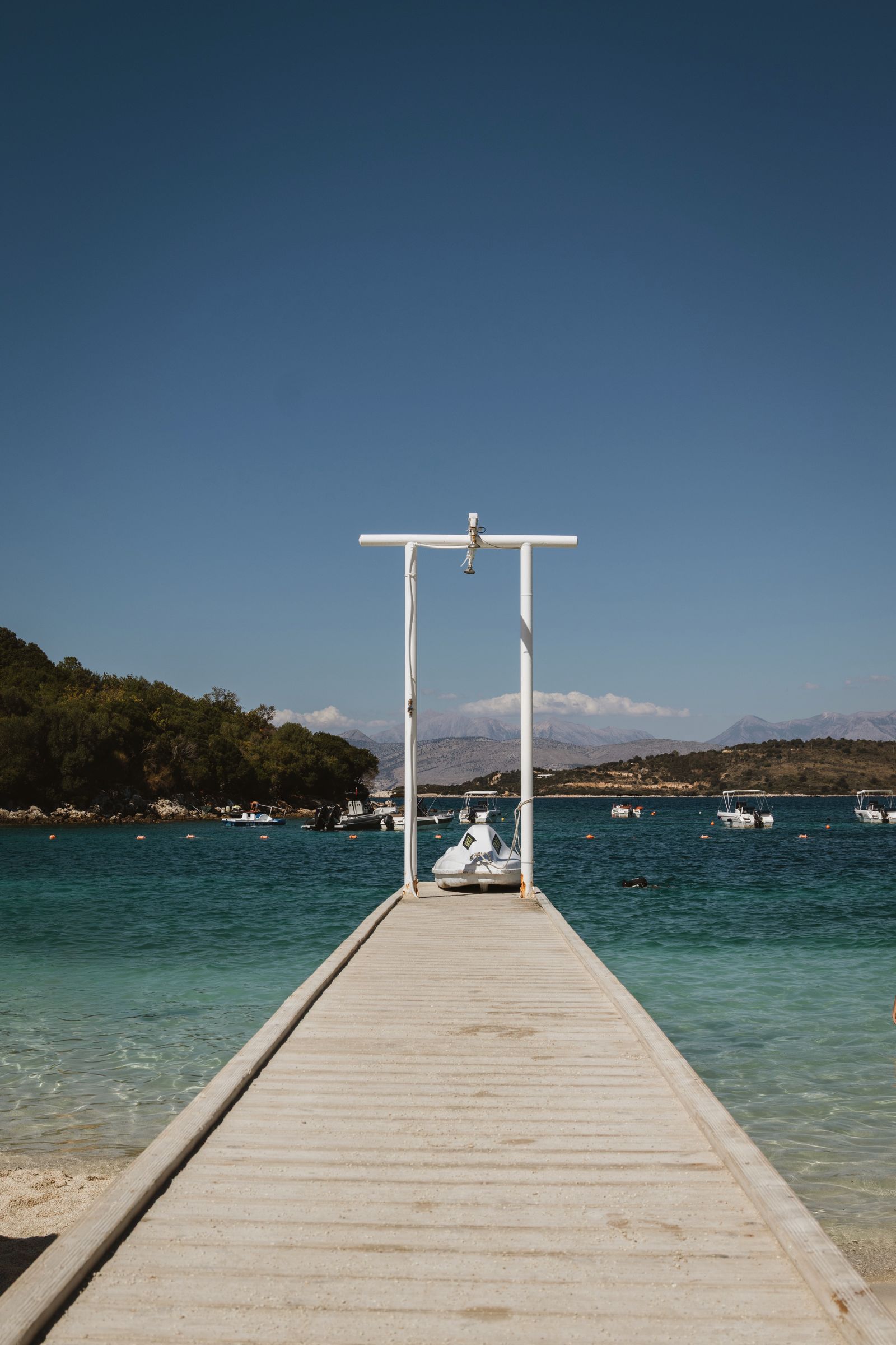 Wooden pier over clear turquoise water at Ksamil on the Albanian Riviera