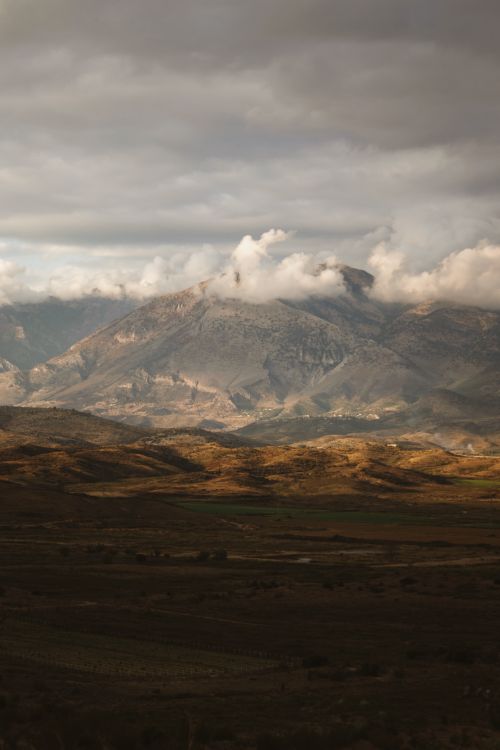 Free Stunning view of mountains in Gjirokastër, Albania at sunset with dramatic clouds. Stock Photo