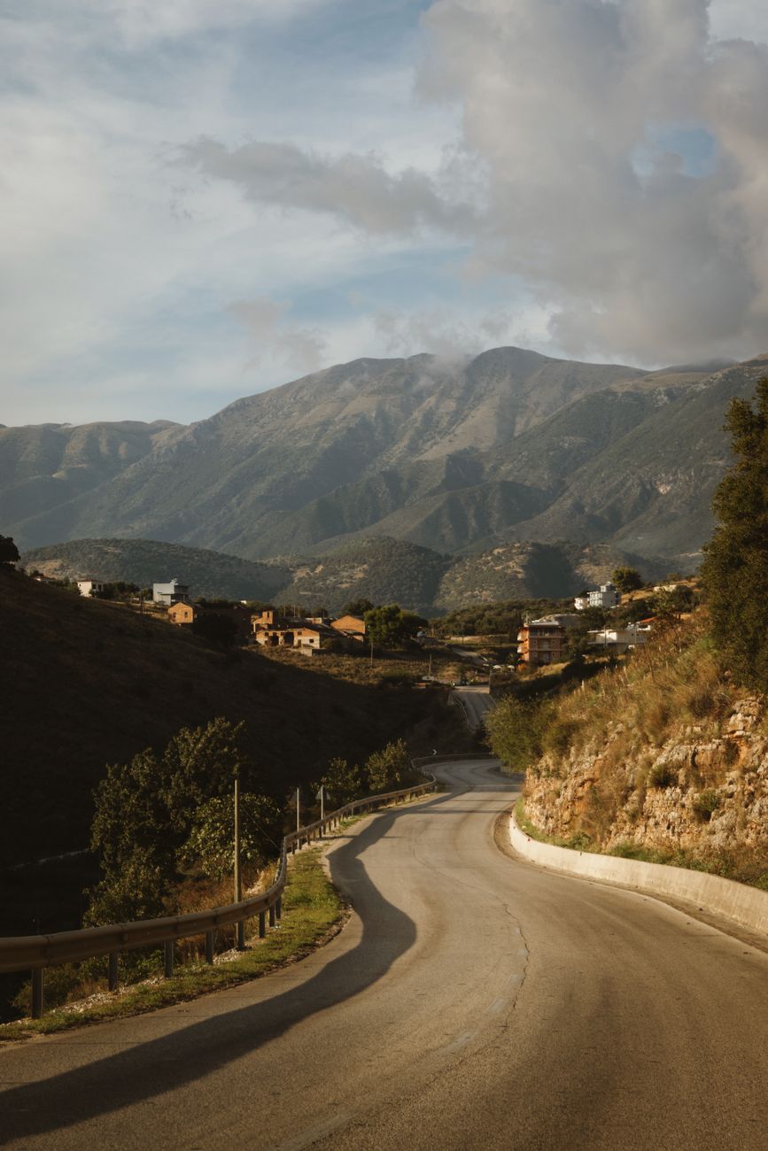 Discover the winding road through Orikum in Vlorë County, Albania, framed by majestic mountains.
