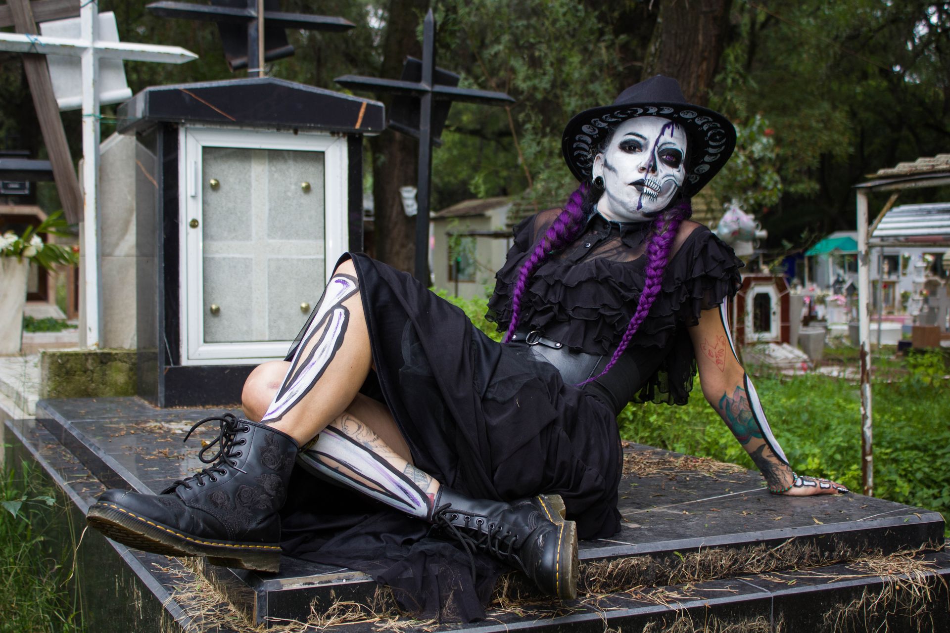 A stunning Catrina figure poses in a vibrant cemetery setting in Ciudad de México.