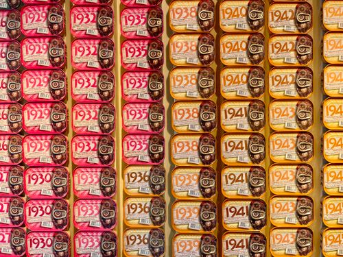 Free A vibrant display of vintage sardine cans arranged by year in a store setting. Stock Photo