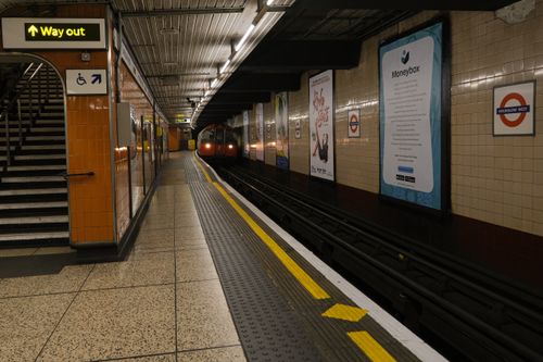 Free Capture of an underground train approaching at a London Tube station. Iconic signage adds to the urban scene. Stock Photo