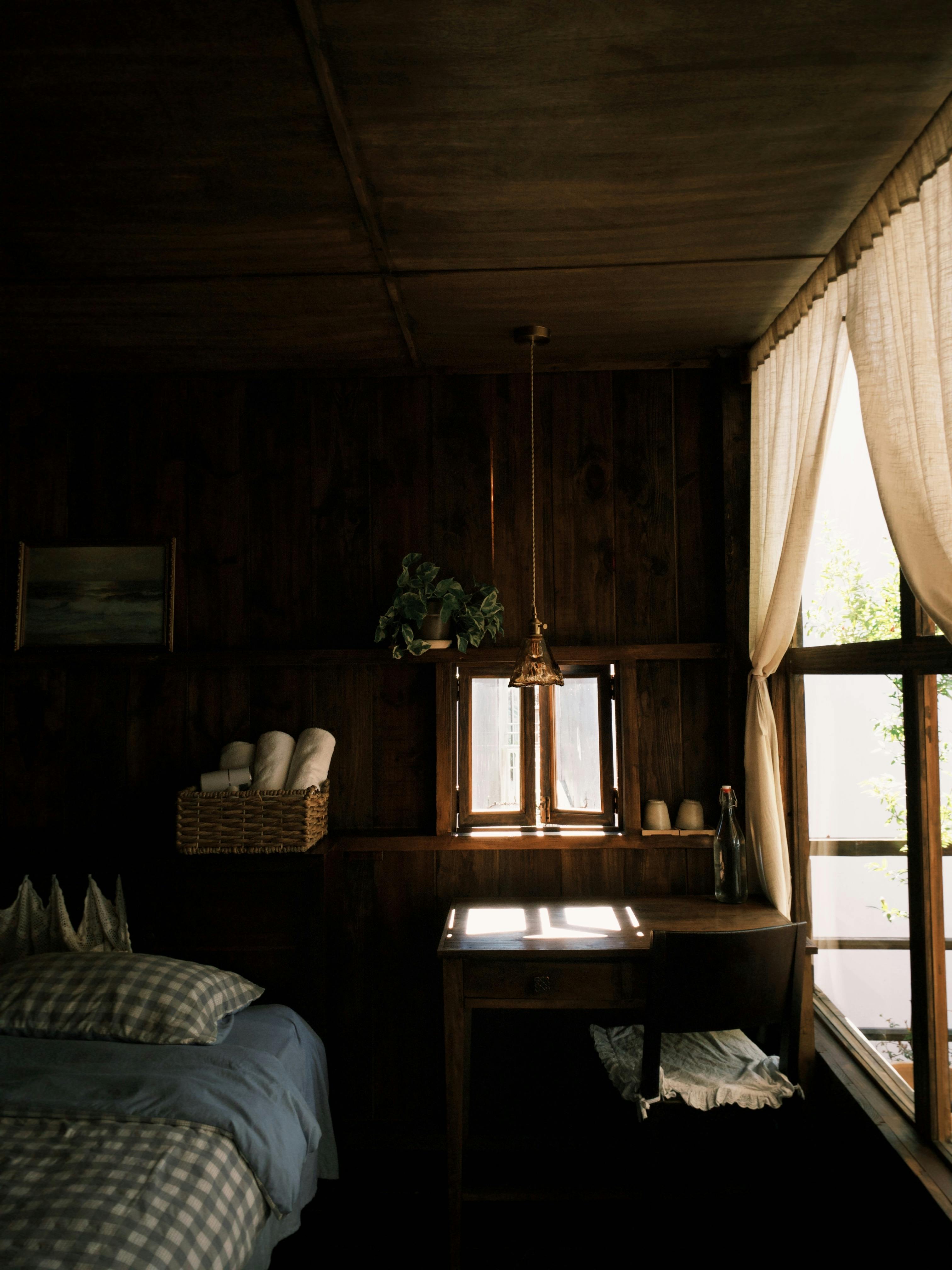 A warm, rustic bedroom with natural light streaming through the curtains.