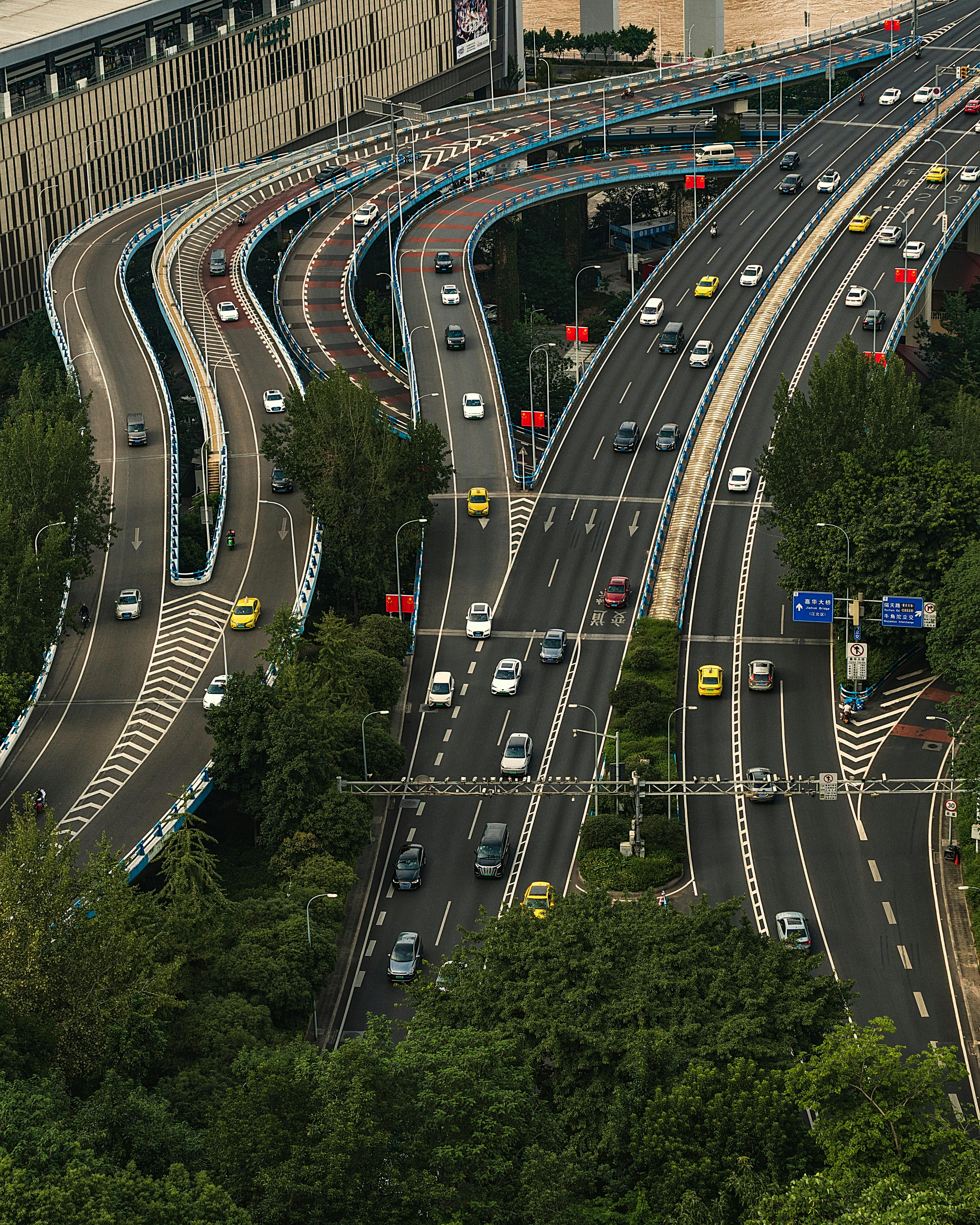 Dynamic aerial shot of a complex highway intersection amidst urban greenery.