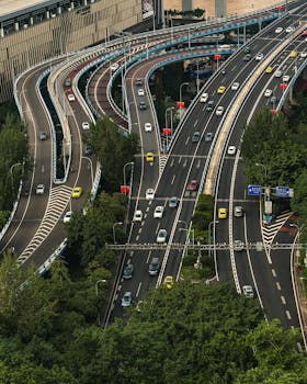 Dynamic aerial shot of a complex highway intersection amidst urban greenery.