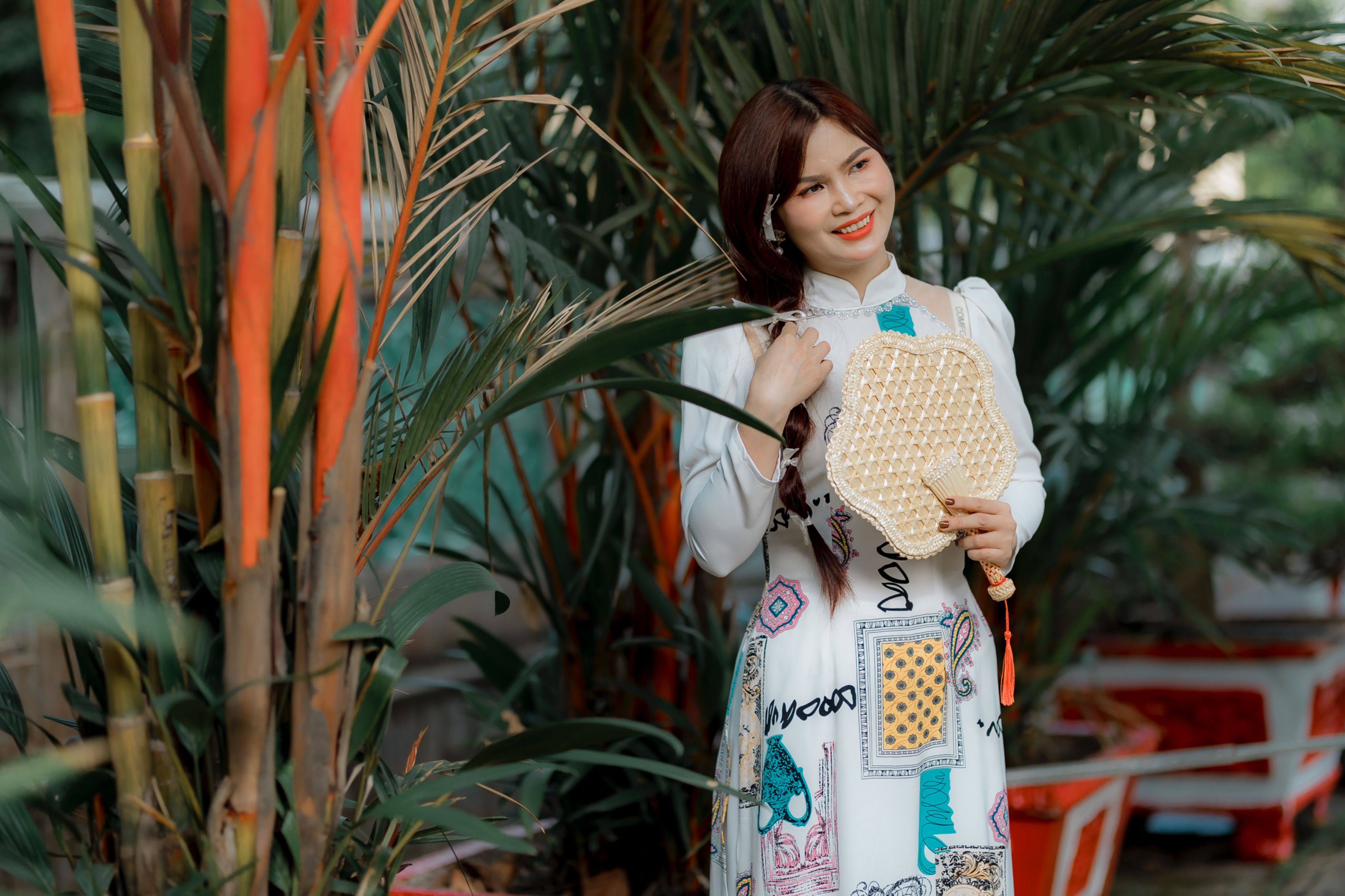 Smiling Woman in Traditional Dress Among Palm Trees · Free Stock Photo