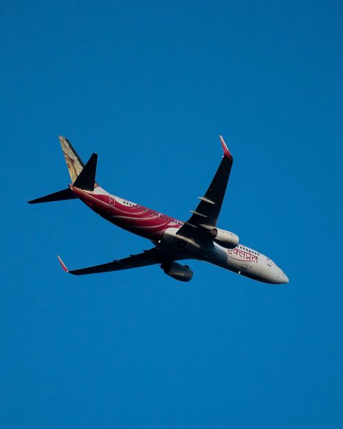 Free Commercial airplane flying against a vivid blue sky, showcasing aviation and travel themes. Stock Photo