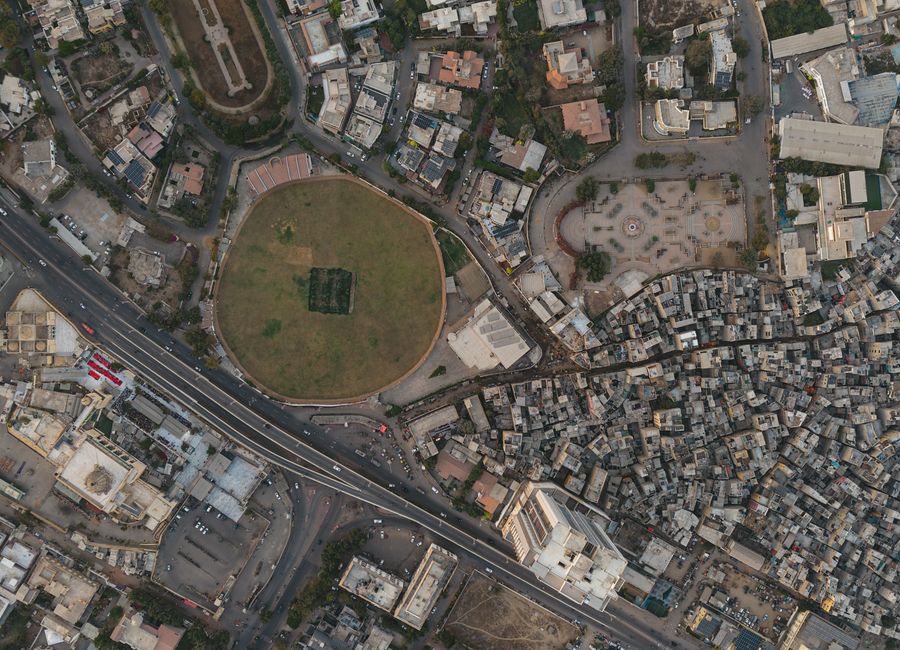 A detailed aerial shot of Karachi showing dense settlements and a distinct circular park, highlighting urban development.
