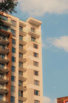 Stylish modern high-rise building with clear blue sky background.