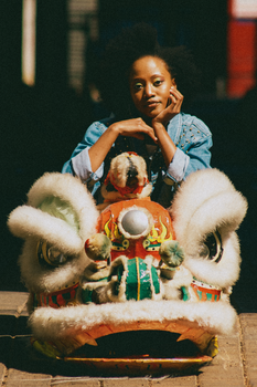 A woman poses with a Chinese dragon head, celebrating culture in Johannesburg.