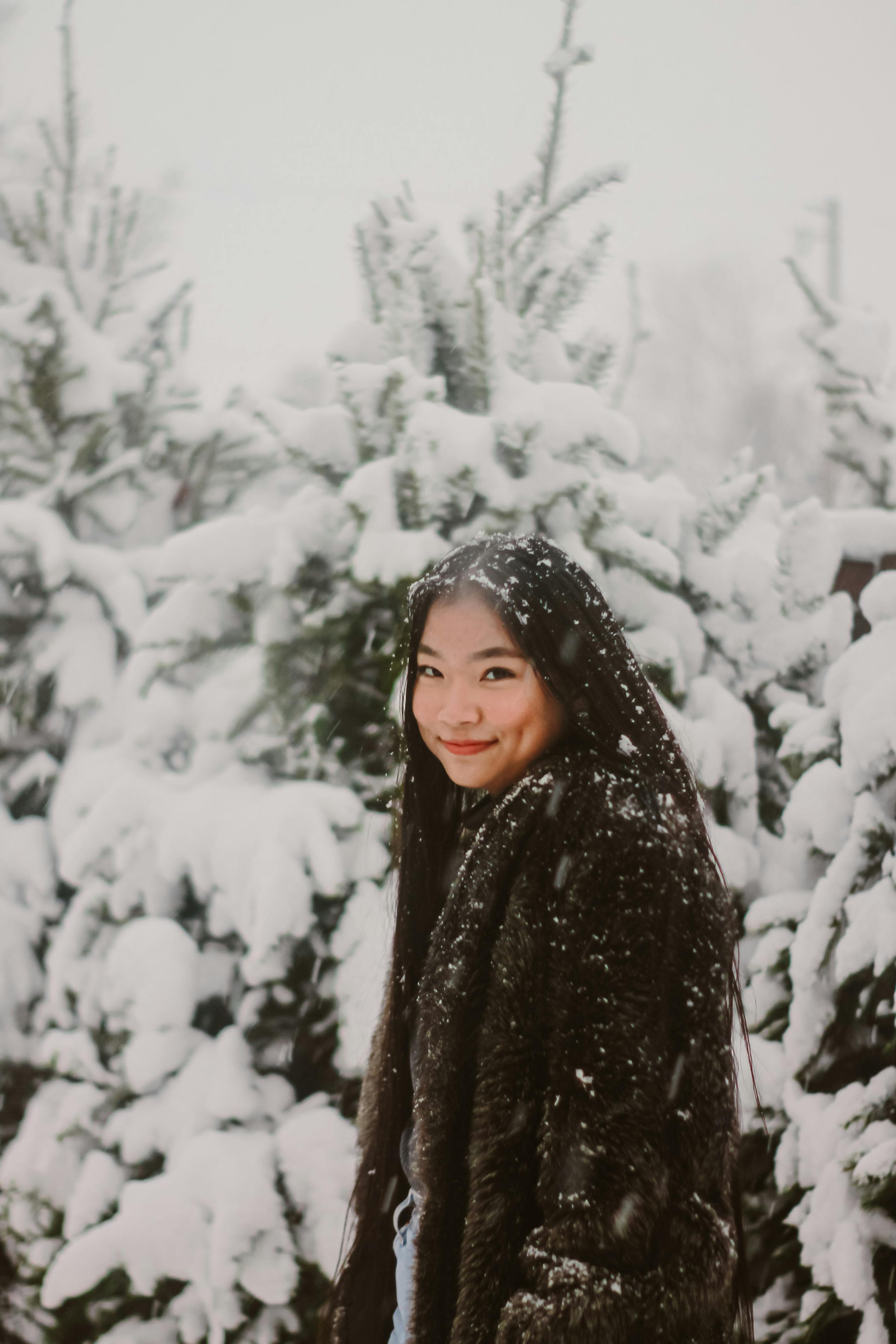 Full body portrait of young woman walking in snowy winter park