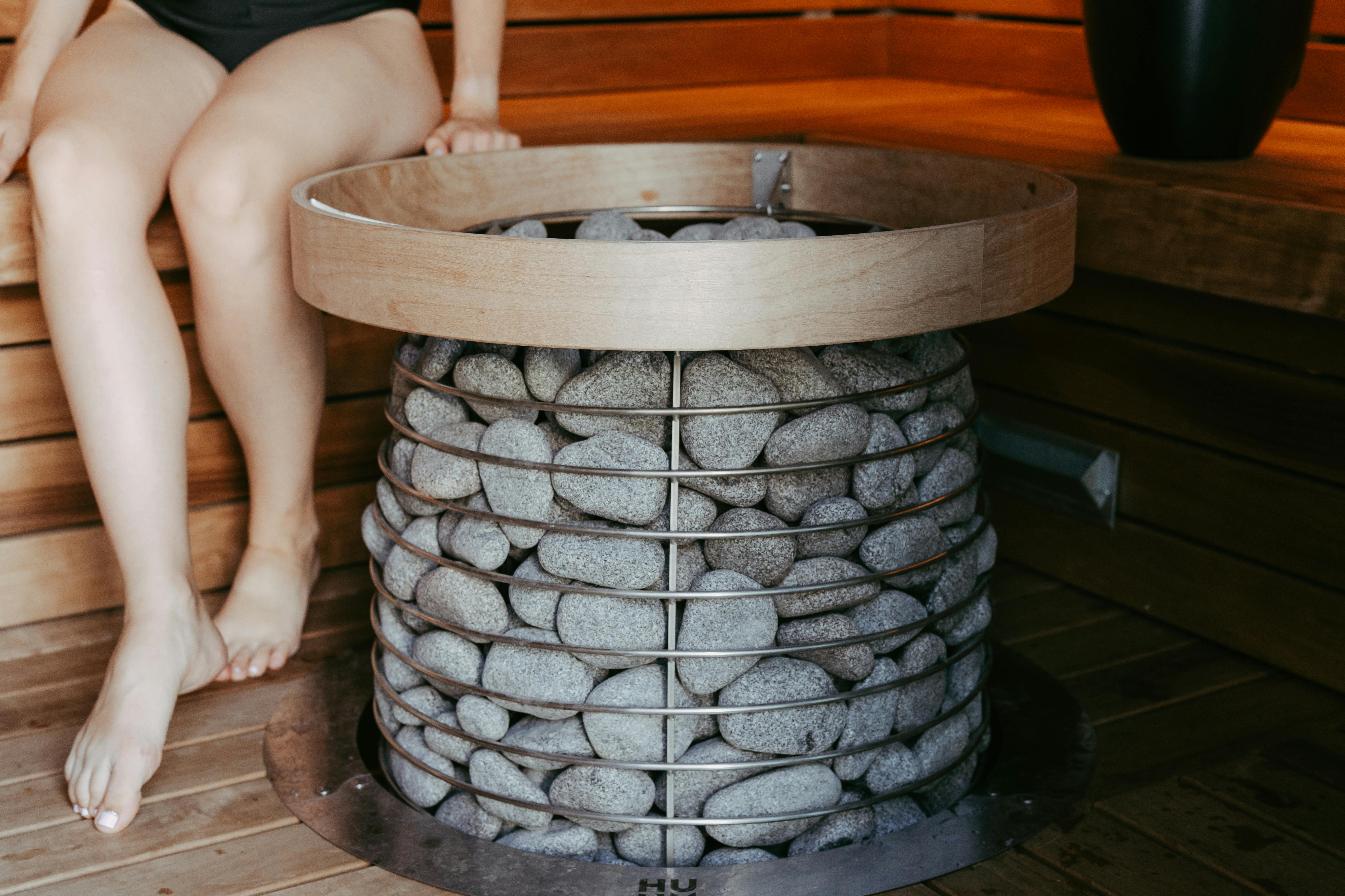 Person enjoying a relaxing session in a wooden sauna.